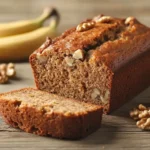 Freshly baked banana nut bread sliced on a wooden table